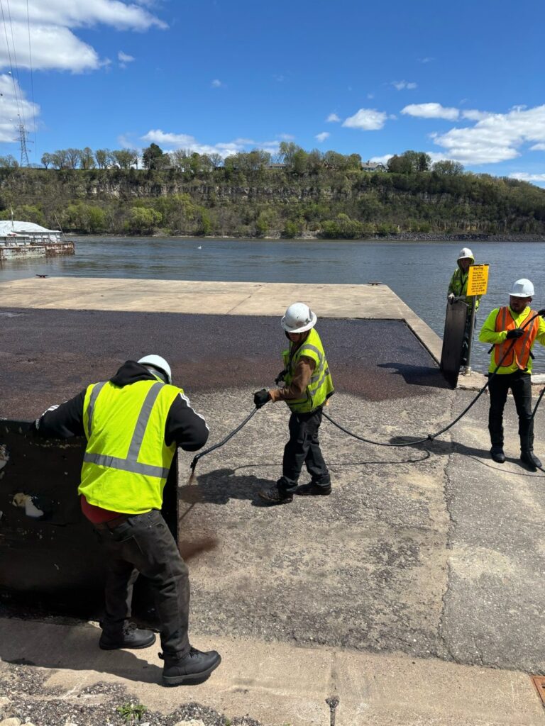 Perfect Path Pavers crew spraying sealcoat on asphalt