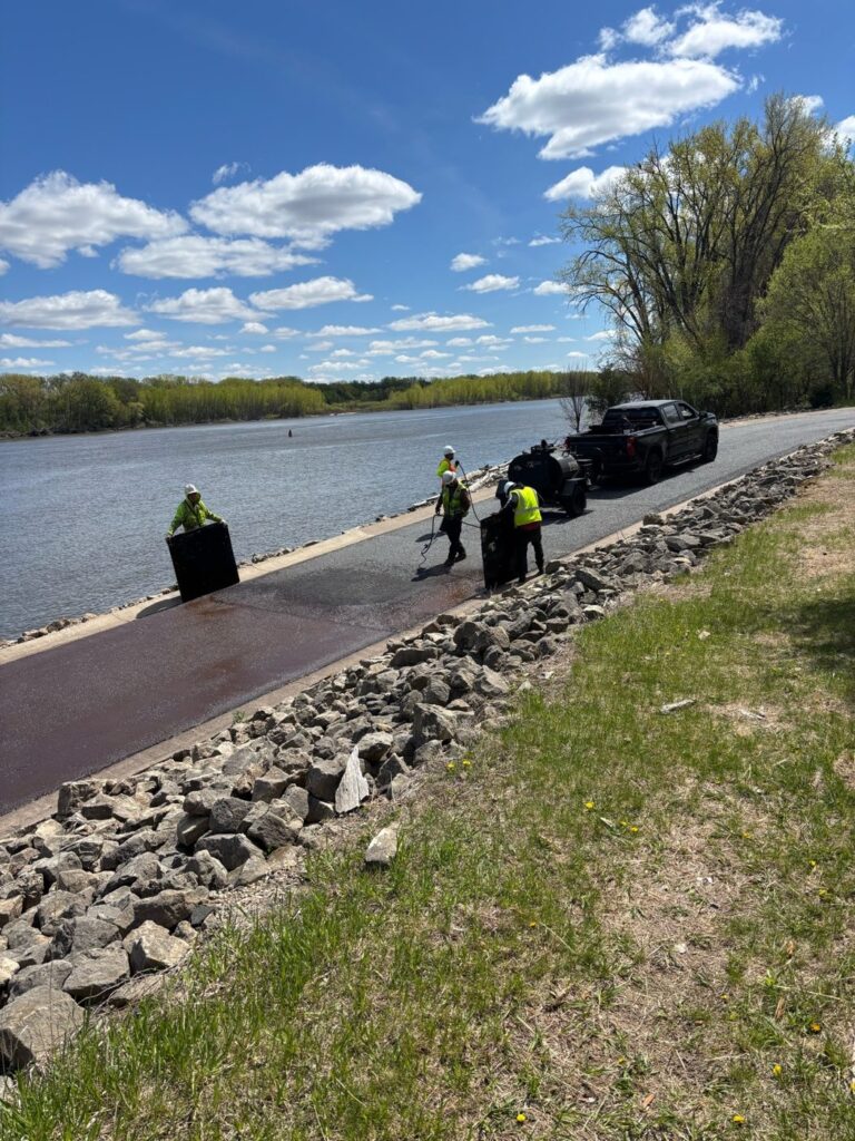 Perfect Path Pavers crew spraying sealcoat on asphalt